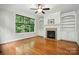 Bright living room with hardwood flooring, fireplace with tile surround and built in shelving at 4133 Hoffmeister Dr, Waxhaw, NC 28173