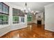 Open living room featuring hardwood floors, fireplace, and large windows with wooded views at 4133 Hoffmeister Dr, Waxhaw, NC 28173