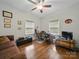 Cozy bedroom with hardwood floors, a ceiling fan, a brown sofa, and a workspace at 419 Wade St, Wadesboro, NC 28170