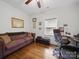 Charming bedroom featuring hardwood floors, brown sofa and a workspace with comfortable desk chair at 419 Wade St, Wadesboro, NC 28170