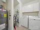 Well-equipped laundry room with washer, dryer, storage cabinets, and hot water heater at 419 Wade St, Wadesboro, NC 28170