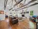 Cozy living room featuring exposed wood beams, a fireplace, hardwood floors, and ample natural light at 419 Wade St, Wadesboro, NC 28170