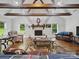 Bright living room with white brick fireplace, hardwood floors, wood beams and comfortable seating arrangement at 419 Wade St, Wadesboro, NC 28170