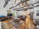 Open-concept living room with high ceilings, wood beams, hardwood floors, and a seamless flow to the kitchen at 419 Wade St, Wadesboro, NC 28170