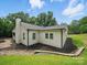 Home's exterior featuring white siding, a brick chimney, and a stone-lined garden bed at 419 Wade St, Wadesboro, NC 28170