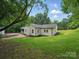 White siding and brick exterior with a patio area and a large, green lawn at 419 Wade St, Wadesboro, NC 28170
