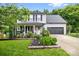 Charming two-story home with manicured lawn and a welcoming front porch and gray siding and black shutters at 4236 Carrington Sw Ct, Concord, NC 28027