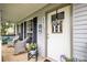 Inviting front porch with comfortable seating, decorative wreath, and well-maintained landscaping at 4236 Carrington Sw Ct, Concord, NC 28027