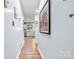 Light filled hallway leads to kitchen with wood floors and calming blue walls at 4236 Carrington Sw Ct, Concord, NC 28027