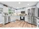 Modern kitchen with white cabinets, stainless steel appliances, granite countertops, and wood floors at 4236 Carrington Sw Ct, Concord, NC 28027