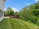 The backyard has a deck overlooking the lawn, complemented by lush greenery and mature trees at 4576 Fox Ridge Ln, Fort Mill, SC 29707