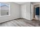 Bedroom features a window, a closet door, and neutral-colored walls complemented by wood-look flooring at 4576 Fox Ridge Ln, Fort Mill, SC 29707