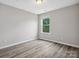 A bright bedroom features a window and neutral walls complemented by wood-look flooring at 4576 Fox Ridge Ln, Fort Mill, SC 29707