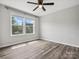 Sunlit bedroom with a large window, hardwood floors, and neutral walls at 4576 Fox Ridge Ln, Fort Mill, SC 29707