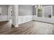 Dining room featuring hardwood floors, grey walls, wainscoting detail, and a modern light fixture at 4576 Fox Ridge Ln, Fort Mill, SC 29707