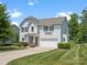 Well-manicured lawn and landscaping surround this light blue two-story home with a two-car garage at 4576 Fox Ridge Ln, Fort Mill, SC 29707