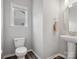 Neutral half bathroom featuring hardwood floors, a pedestal sink, and a window for natural light at 4576 Fox Ridge Ln, Fort Mill, SC 29707