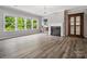 Bright living room with large windows overlooking lush greenery, with hardwood floors and a fireplace at 4576 Fox Ridge Ln, Fort Mill, SC 29707