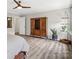 Main bedroom featuring wood-look floors, a ceiling fan, and a rustic armoire at 4576 Fox Ridge Ln, Fort Mill, SC 29707