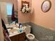 Cozy bathroom features pink walls, floral wallpaper, and an ornate mirror at 508 Hillcrest St, Marshville, NC 28103
