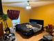 Bedroom features yellow walls, an adjustable bed with blue headboard, and light wood laminate flooring at 508 Hillcrest St, Marshville, NC 28103