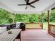 Charming covered deck with a fan, wood railings, outdoor seating and scenic backyard views at 5369 Concord Rd, York, SC 29745