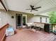 Relax on this covered deck featuring patio furniture and a fan, perfect for outdoor entertaining at 5369 Concord Rd, York, SC 29745