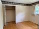 Cozy bedroom features hardwood floors, trim wallpaper, and a convenient closet space at 6018 Unionville Rd, Monroe, NC 28110