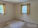 A bright bedroom with two windows and neutral carpet provides a calming space at 6018 Unionville Rd, Monroe, NC 28110