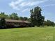 Single story home features a large front yard with mature trees, shrubs, and well-manicured lawn at 6018 Unionville Rd, Monroe, NC 28110