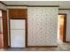 Kitchen features white appliances, floral wallpaper, and doorway to other rooms at 6018 Unionville Rd, Monroe, NC 28110