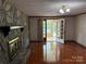 Bright living room featuring a stone fireplace, wood floors, and doorway to the sunroom at 6018 Unionville Rd, Monroe, NC 28110
