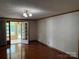 Living room features wood floors, neutral-toned wallpaper, and doorway to the sunroom at 6018 Unionville Rd, Monroe, NC 28110