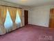 Cozy living room features pink carpet, natural light from large windows, and a combination of doors at 6018 Unionville Rd, Monroe, NC 28110