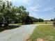 A long gravel driveway leads through a verdant landscape with outbuildings and fields at 6018 Unionville Rd, Monroe, NC 28110