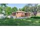 A brick house with a wooden deck overlooks a well-manicured lawn and partial white picket fence at 616 26Th Nw St, Hickory, NC 28601