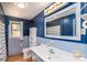 Stylish blue bathroom featuring a vanity with a sink, a toilet, and blue tiled walls at 616 26Th Nw St, Hickory, NC 28601