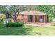 Charming brick home featuring a covered porch with a seating area, a mature tree and lush landscaping at 616 26Th Nw St, Hickory, NC 28601