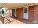Covered front porch features a brick facade, white trim, and outdoor access to the home at 616 26Th Nw St, Hickory, NC 28601