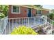 Charming brick home showcasing a cozy front porch with an ornate white railing and seating area at 616 26Th Nw St, Hickory, NC 28601