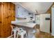 Cozy kitchen featuring wood paneling, tile backsplash, granite countertops, and modern appliances at 616 26Th Nw St, Hickory, NC 28601