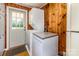 Convenient laundry area featuring a stacked washer and dryer, wood paneling, and a back door at 616 26Th Nw St, Hickory, NC 28601
