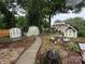 Serene backyard with storage sheds, a quaint seating area, and mature trees at 6300 Fox Hunt Rd, Indian Trail, NC 28079
