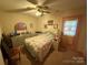 Bedroom featuring a ceiling fan, bed, dresser, and exterior door at 6300 Fox Hunt Rd, Indian Trail, NC 28079