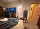 A bedroom featuring a large television, security safe, and multiple pairs of shoes at 6300 Fox Hunt Rd, Indian Trail, NC 28079