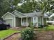 Inviting home showcasing green siding, white trim, a covered porch, attached garage, and established landscaping at 6300 Fox Hunt Rd, Indian Trail, NC 28079