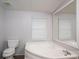 Bathroom with a soaking tub with tile surround, toilet, and window with blinds at 6903 Knottywood Ln # 21, Vale, NC 28168