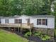 Charming home with a front porch, white siding, stone foundation, and surrounded by lush greenery at 6903 Knottywood Ln # 21, Vale, NC 28168