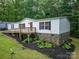 Charming home with a front porch, white siding, stone foundation, and surrounded by lush greenery at 6903 Knottywood Ln # 21, Vale, NC 28168