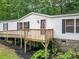 Charming home with a front porch, white siding, stone foundation, and surrounded by lush greenery at 6903 Knottywood Ln # 21, Vale, NC 28168